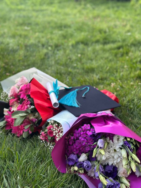 A colorful assortment of floral bouquets arranged on a lush green grass surface, featuring an array of fresh flowers including pink roses, purple and white eustoma, and vibrant pink blossoms wrapped i