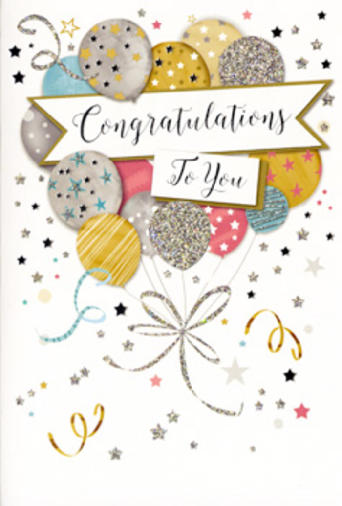 The photograph captures a tall congratulations card standing alone, its front artwork creating a refined yet playful vision of celebration that would feel at home in any Egham living room. Dominating the centre is a cluster of illustrated balloons that rise in an airy bouquet, each balloon rendered with soft gradients that make them appear three-dimensional and lightly inflated. The palette is carefully balanced: metallic golds, silvers, and champagne tones mix with sky blue, blush pink, and subtle grey, resulting in a look that feels festive but never garish. Some balloons are speckled with star motifs, others lined with delicate stripes or glitter-like highlights that give the sense of texture and sparkle, as if they were brushed with fine shimmer under warm indoor lighting. From the base of each balloon, slender strings fall in flowing lines of gold and silver, curling and crossing one another until they gather in a graceful tangle, reminiscent of the way ribbon trails from a hand-tied bouquet prepared at Flower Delivery Egham. Across the centre of the balloon cluster, a wide banner sweeps gently across the card. On this banner, Congratulations To You is written in elegant, slightly flourished script that suggests both celebration and respect, the sort of message you might choose for exam success, a new job, or a personal milestone. The background remains soft and neutral, sprinkled with tiny stars, confetti dots, and looping streamers that drift gently across the surface, evoking the light-hearted mood of a small party near Runnymede or along The Green. Altogether, the design radiates quiet joy and pride, perfectly suited to accompany fresh flowers when you want your congratulations to feel heartfelt and beautifully presented.