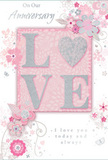 This anniversary card conveys a sense of treasured romance, its surface bathed in soft pastel pinks, silvery greys, and gentle ivory tones that suit the calm, residential character of Egham. At its heart, the word LOVE appears in raised, softly sparkling glitter, each letter defined yet delicately rounded, inviting a finger to trace its contours. The letter O is transformed into a shimmering silver heart, its texture slightly more pronounced, so it catches light with a subtle brilliance, much like a keepsake pendant. Encircling this centrepiece, delicate blossoms unfurl in shades of blush, mauve, and pale cream, their edges softened as though painted in watercolor. The petals layer gracefully, forming small, romantic clusters that mirror the style of a florist's carefully composed bouquet. Fine lines and swirls of vines weave between the flowers, their pale grey and silver outlines introducing a soft sense of movement, like branches gently swaying in a light breeze over Egham's riverside walks. Tiny petals, curving scrolls, and discreet butterfly motifs are scattered through the design, adding whimsical notes without crowding the central LOVE and heart. The background is a quiet wash of powder pink, providing a warm, intimate backdrop that allows the metallic accents and floral details to stand out. In a refined, flowing script, the phrases On Our Anniversary and I love you today and always are written, their letterforms echoing the curves of the vines and petals. The result is a visually soothing, deeply affectionate card-an ideal complement to an anniversary bouquet from Flower Delivery Egham, created for couples who want to mark their shared journey with something softly spoken yet profoundly heartfelt.